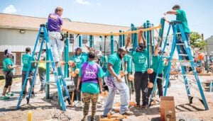 Members of a community work together to build a playground to support civic infrastructure