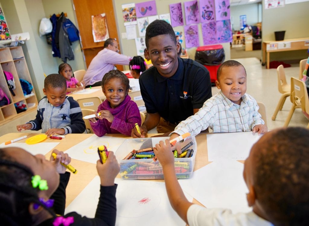 Children and an educator work on a lesson