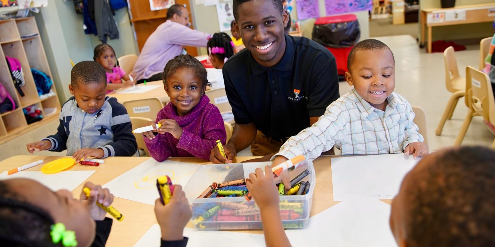 Children and an educator work on a lesson