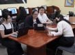 High school students sitting around a table with laptops