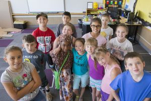 A group of young students smiling up at the camera