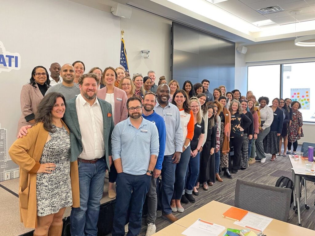 A group photo of the entire StriveTogether staff, standing in rows and smiling at the camera.