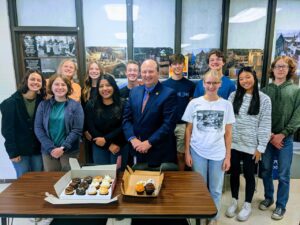 A group of 11 students pose for a picture with Matt Hillman, Northfield Public Schools superintendent.