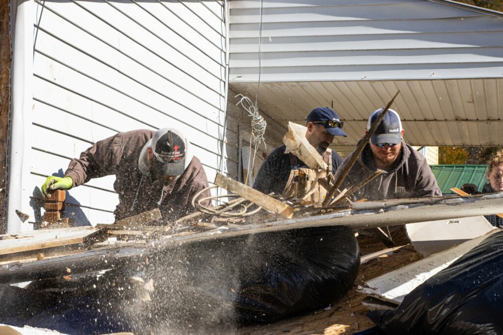 Three men work to clear debris in the aftermath of the 2022 flood in Eastern Kentucky.