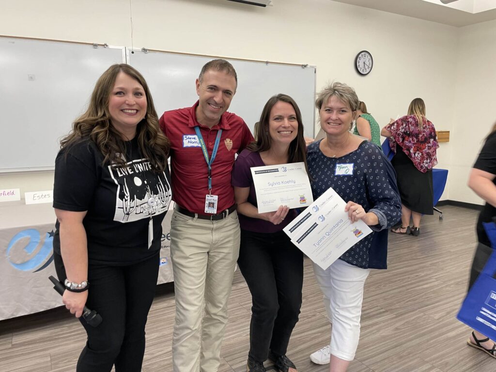 Four teachers who participated in a Leaders in Literacy program smile at the camera